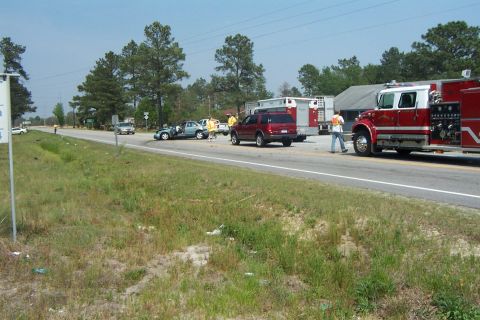 1998 Ford Crown Victoria - Emergency responders are present at a multi-vehicle accident scene on a sunny day.