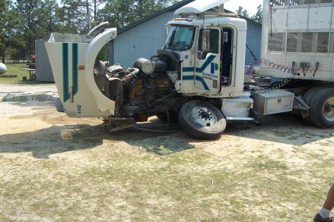 1998 Ford Crown Victoria - Damaged semi-truck with its hood open, revealing the engine compartment.