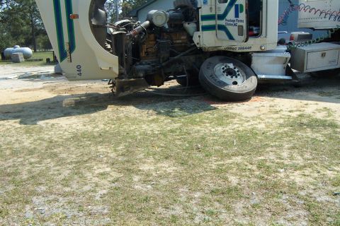 1998 Ford Crown Victoria - A damaged semi-truck sits with its hood open and a flat tire, indicating a recent incident.