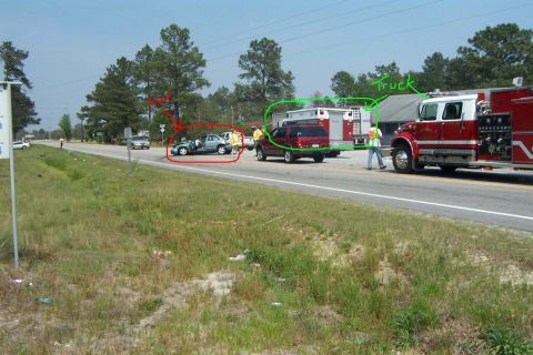 1998 Ford Crown Victoria - Emergency responders are present at a roadside accident involving a sedan and other vehicles.