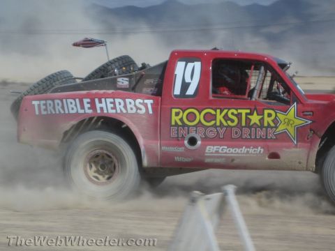 1990 Ford Bronco - red off-road race truck number 19 lettered Terrible Herbst and Rockstar Energy Drink races over a desert course.