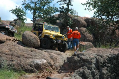 2001 Jeep Wrangler - Two Jeeps on a rocky trail, one yellow and one brown, with two men observing.