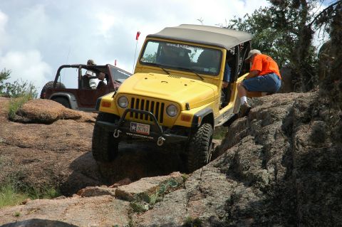 2001 Jeep Wrangler - Two Jeeps navigate a rocky off-road trail under a cloudy sky.