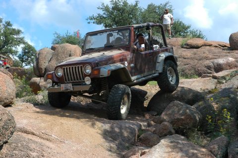 2001 Jeep Wrangler - Jeep Wrangler navigating a rocky off-road course under a partly cloudy sky.