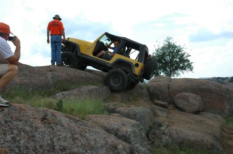 2001 Jeep Wrangler - Yellow 2001 Jeep Wrangler navigates rocky terrain while a trail guide observes.