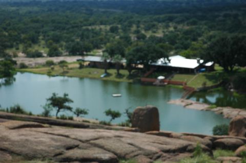 2001 Jeep Wrangler - A scenic view of a lake surrounded by lush greenery and buildings, captured from a rocky outcrop.