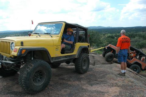 2001 Jeep Wrangler - Two Jeeps navigate a rocky off-road trail with a trail guide observing the action.