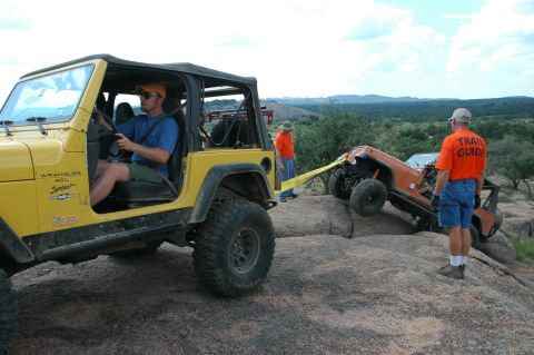 2001 Jeep Wrangler - Two Jeep Wranglers navigate a challenging rocky terrain, with one assisting the other.