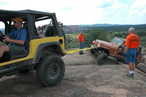 2001 Jeep Wrangler - Two Jeep Wranglers navigate a rocky trail, with one assisting the other with a tow strap.