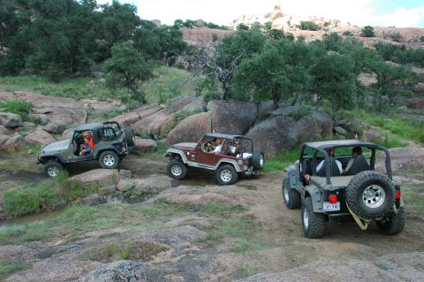 2001 Jeep Wrangler - Three Jeep Wranglers traverse a , rocky landscape, their off-road capabilities.