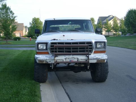 1978 Ford Bronco - Front view of a white 1978 Ford Bronco with a prominent grille guard and visible wear on the bumper.