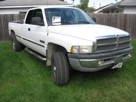 1978 Ford Bronco - This white Dodge Ram pickup truck is shown from a 3/4 front angle, parked on a grassy lawn.