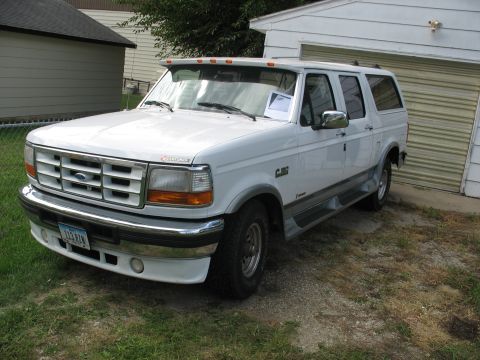 1978 Ford Bronco - This 1995 Ford F-150 extended cab pickup truck is parked in front of a garage.