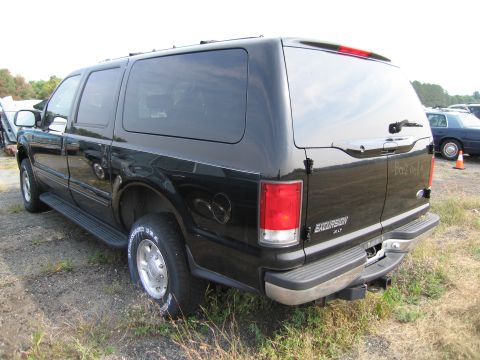 1991 Ford LTD Crown Victoria - Black Ford Excursion SUV with "Boss Hogg" text on the tailgate, parked outdoors.