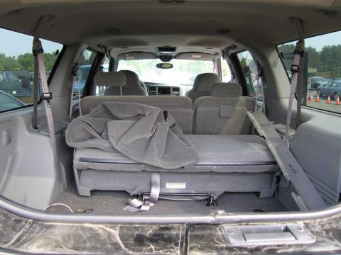 1991 Ford LTD Crown Victoria - The interior of a large SUV shows folded seats and seatbelts, with a view of the dashboard and windows.