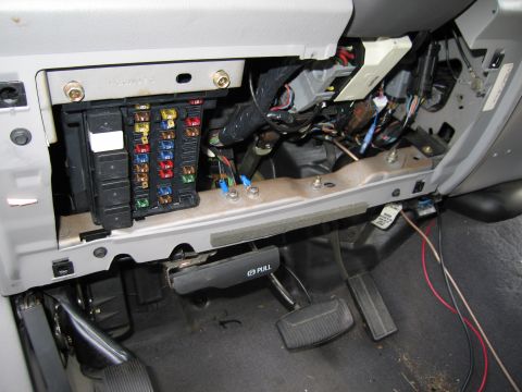 1991 Ford LTD Crown Victoria - Interior view of a vehicle's fuse box and wiring harness located under the dashboard.