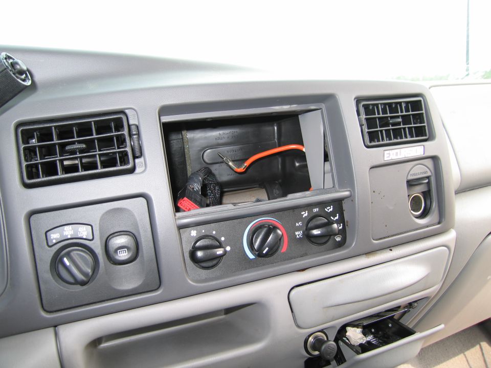 Dashboard of a vehicle with an empty radio slot and climate controls