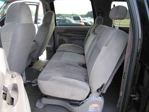 1991 Ford LTD Crown Victoria - Rear interior of a truck, showing cloth seats and the view through the windows to other vehicles.
