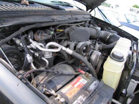 1991 Ford LTD Crown Victoria - Close-up view of a vehicle's engine bay, showing various components like the battery and alternator.
