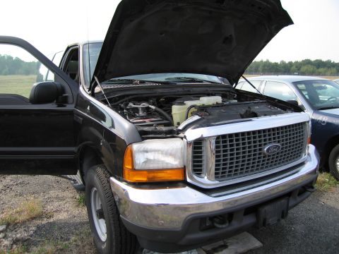 1991 Ford LTD Crown Victoria - Front view of a black Ford truck with its hood and driver's door open, revealing the engine compartment.