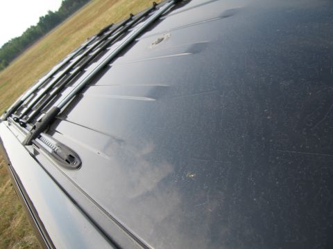1991 Ford LTD Crown Victoria - A close-up view of a vehicle's roof, revealing a roof rack and a dusty, scratched surface.