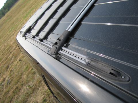 1991 Ford LTD Crown Victoria - Close-up view of the roof rack rails on a dark-colored vehicle.