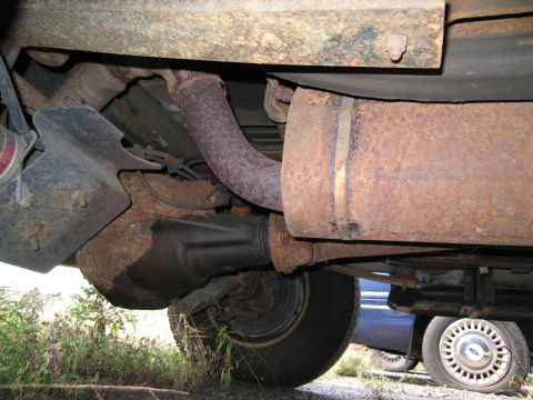 1991 Ford LTD Crown Victoria - Undercarriage detail with significant rust on exhaust and differential components.