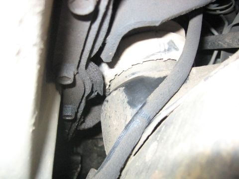 1989 Ford Bronco - This photo shows a close-up view of a vehicle's engine mount, covered in grease and dirt.