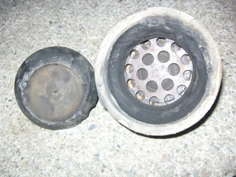 1989 Ford Bronco - A worn engine mount, likely from a vehicle, is shown disassembled on a concrete surface.