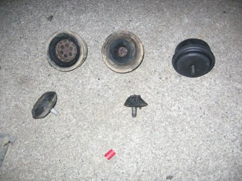 1989 Ford Bronco - Set of engine mounts laid out on concrete. These appear to be various types of rubber and metal isolators.
