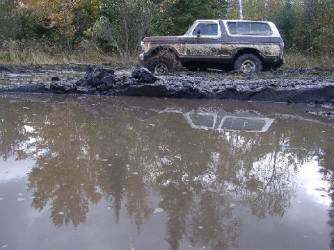 1978 Ford Bronco - This 1978 Ford Bronco is deeply stuck in a muddy mire, its tires submerged in the thick muck.