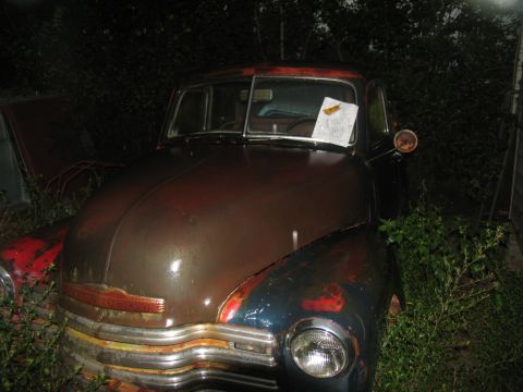 1978 Ford Bronco - Front view of a weathered 1950s Chevrolet truck with visible rust and a paper note on the windshield.