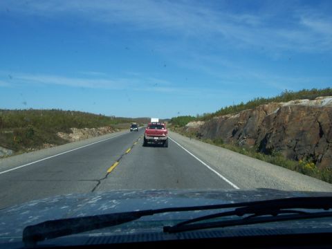 1996 Ford Bronco - Driving behind a red pickup truck on a sunny day on the highway.