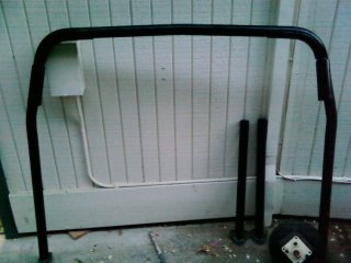 1995 Ford Bronco - A black roll bar and two poles are displayed against a white paneled wall, with a watermark from Supermotors.net visible.
