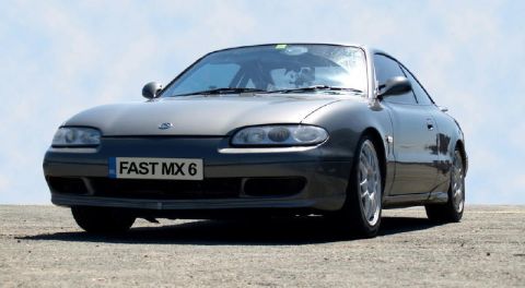 1991 Ford Probe - Gray Mazda MX-6 parked outdoors under a clear sky.