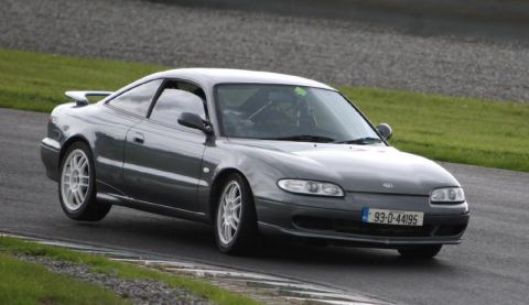 1991 Ford Probe - A gray Mazda MX-6 is shown on a race track with white racing wheels and a spoiler.