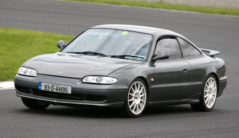 1991 Ford Probe on a racetrack, grey paint, white wheels, Irish license plate 93-D-44195