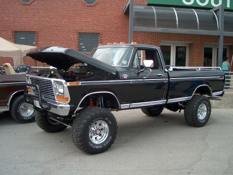 1978 Ford Bronco - This lifted black Ford pickup truck has its hood open, revealing the engine bay.