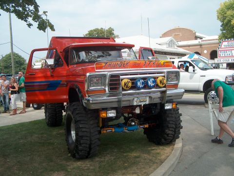 1978 Ford Bronco - A heavily modified 1978 Ford Bronco is parked next to a white truck at an outdoor event.