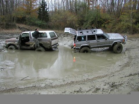 1978 Ford Bronco - Two off-road vehicles, a Ford Bronco and a Jeep Cherokee, are stuck in a muddy mire during an off-road excursion.