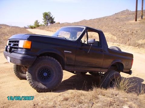 1990 Ford Bronco - This black 1990 Ford Bronco is equipped with off-road tires and is shown on a dirt path.