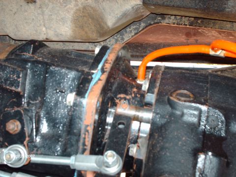 1982 Ford F-100 - Underside view of a vehicle's drivetrain, focusing on a mechanical part with an orange hose attached.