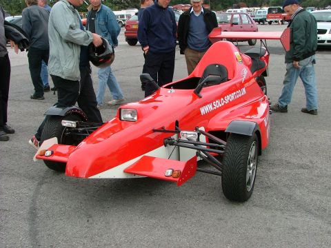 2001 Ford Fiesta - Red three-wheeled sports car with a large rear wing and "www.solo-sport.co.uk" printed on its side.