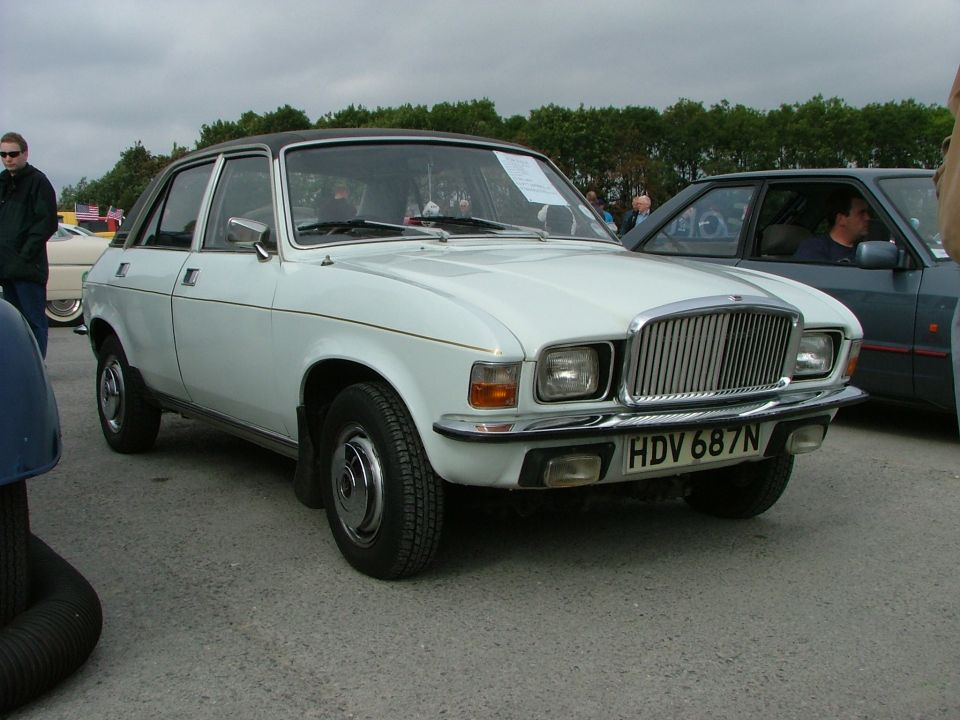 White sedan with black roof and chrome grille parked outside. License plate reads HDV 687N