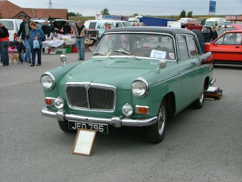 2001 Ford Fiesta - A green sedan with a black roof is parked at an outdoor event, with other vehicles and people in the background.