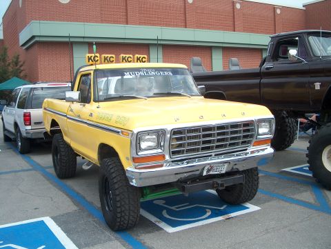 1978 Ford Bronco - This lifted 1978 Ford pickup truck features custom text on the door and a prominent grille.