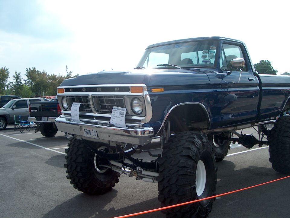 Blue lifted Ford pickup with large tires. License plate reads 5986 ZS