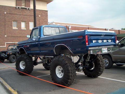 1978 Ford Bronco - This lifted 1978 Ford pickup truck features large off-road tires and a prominent "FORD" tailgate emblem.