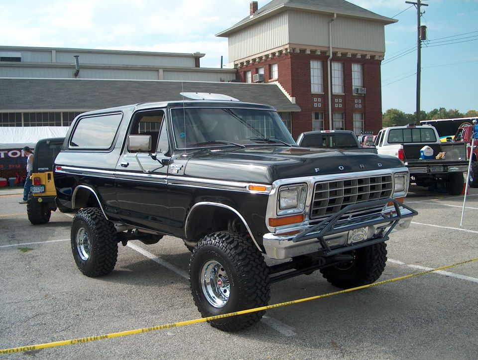 Black 1978 Ford Bronco with lifted suspension and aftermarket bumper, front 3/4 view