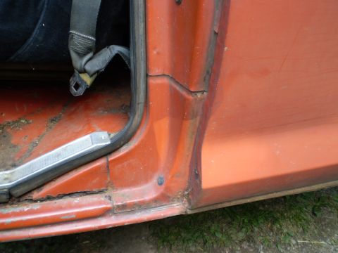 1979 Ford Bronco - The interior door jamb of an older vehicle shows signs of rust and wear.